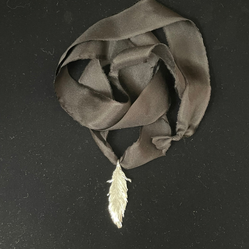 Feather pendant on silk ribbon