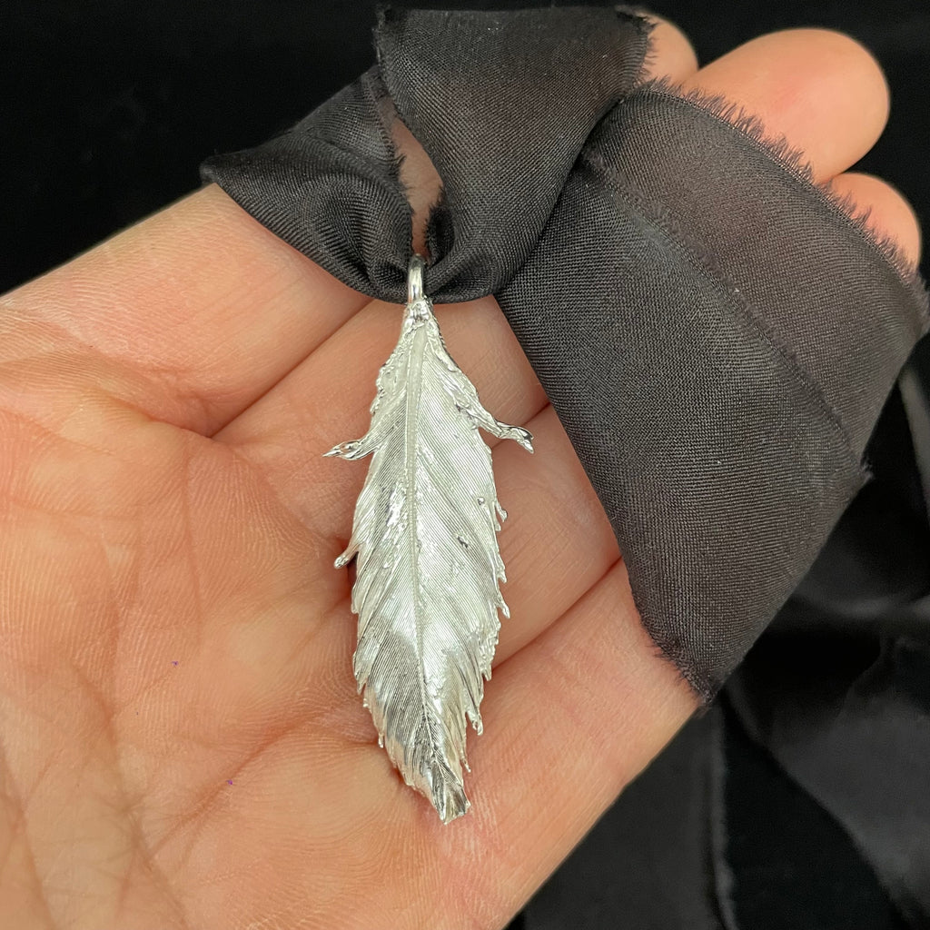 Feather pendant on silk ribbon