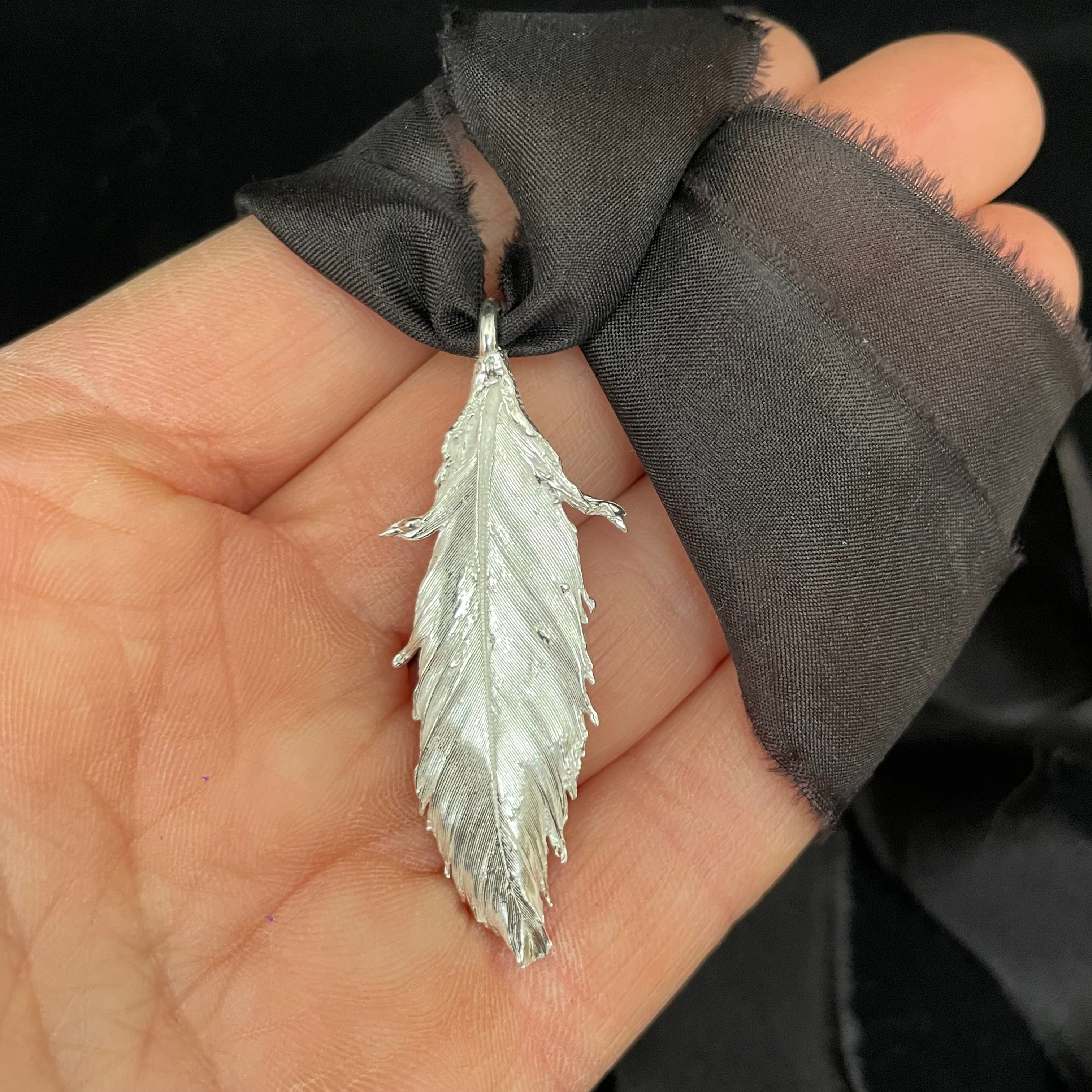 Feather pendant on silk ribbon