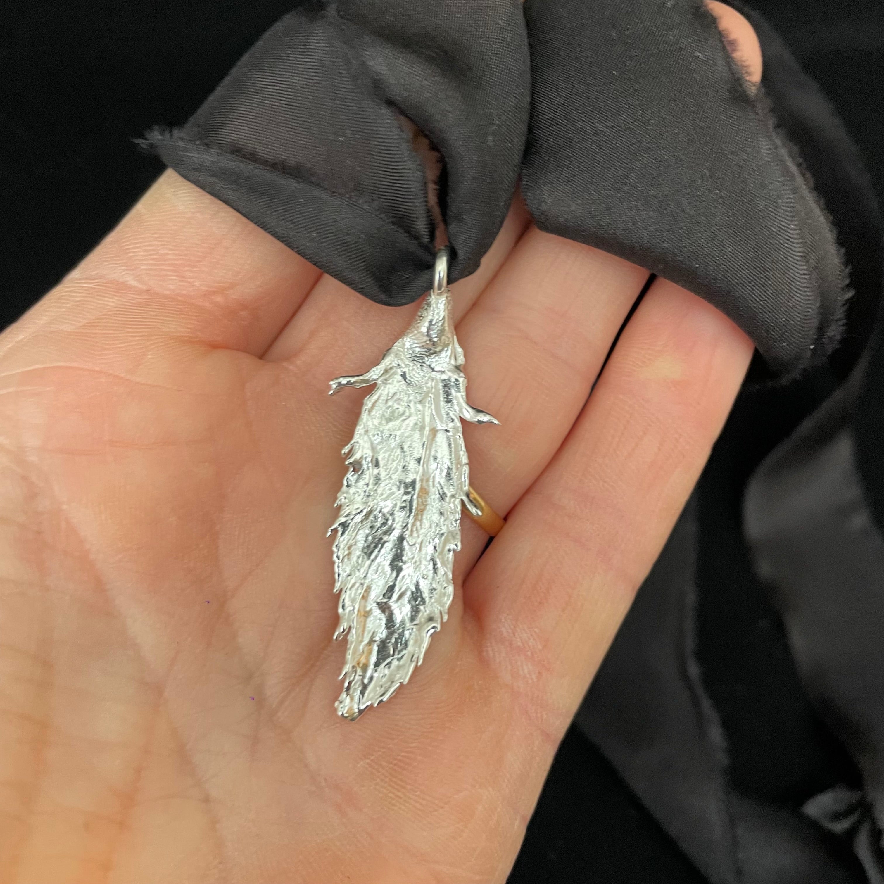 Feather pendant on silk ribbon